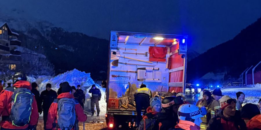 Einsatzkräfte und Helfer stehen bei einem LKW in St. Anton am Arlberg. Foto: Bernhard Flatscher/extremwetter.tv/dpa