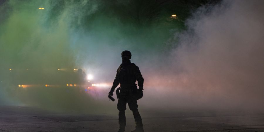 Ein Bundesbeamte der Einwanderungsbehörde ICE ist vor dem Bishop Whipple Federal Building zu sehen, nachdem Tränengas eingesetzt wurde. Nach den tödlichen Schüssen auf eine Frau in ...