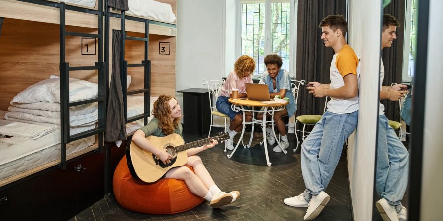 Leute in einem Hostel mit Gitarre und Dorm Room.