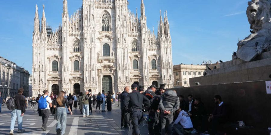Carabinieri sprechen auf der Piazza del Duomo mit Passanten - einen Tag, nachdem Randalierer mit der Polizei zusammengestoßen waren, Geschäfte geplündert und Gebäude in Brand gesetz...
