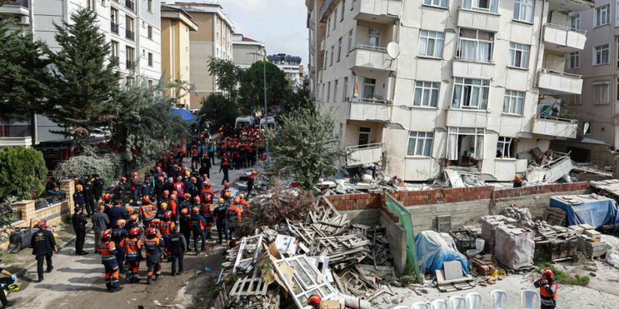 Feuerwehrleute und Rettungskräfte sind an einem eingestürzten mehrstöckigen Gebäude im Einsatz. Foto: Abdullah Tepeli/Dia Photo/AP/dpa