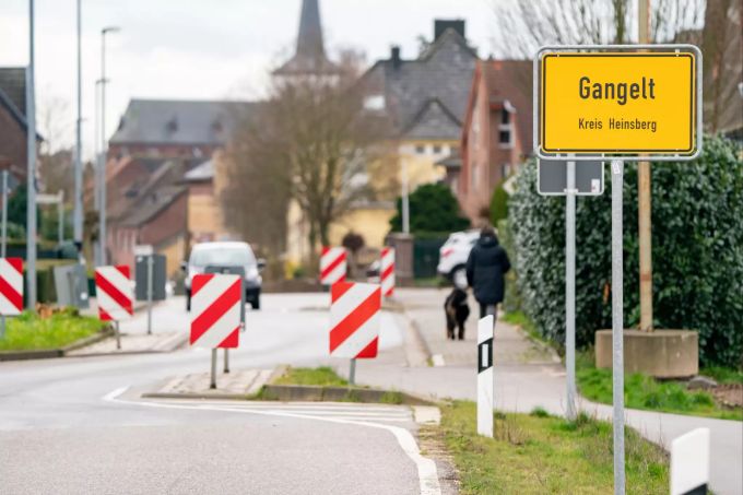 Eine Frau geht mit ihrem Hund durch den Ort. In Gangelt mit rund 12'000 Einwohnern waren aufgrund der Quarantänemassnahmen mehrere Arztpraxen geschlossen worden und die übrigen sehr stark ausgelastet. Coronavirus - Gangelt