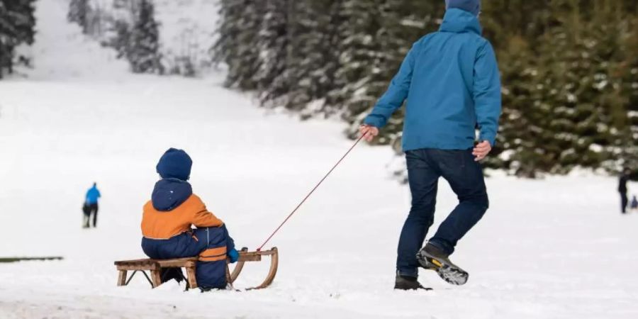 Es gibt keinen Schnee mehr! Eltern, die ihre Kinder auf dem Schlitten durch den Schnee ziehen - die Szene war in den vergangenen Jahren kaum noch zu beobachten. Foto: Swen Pförtner/dpa
