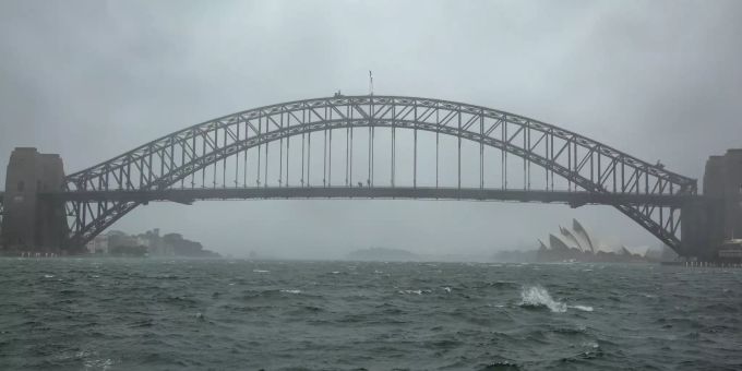 Sydneys Harbour Bridge ist verregnet und der Wind hat das Wasser im Hafen aufgepeitscht. Schwere Unwetter haben weite Teile Australiens heimgesucht. Foto: Bai Xuefei/XinHua/dpa unwetter