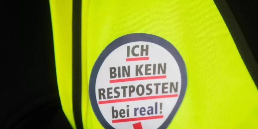 Mitarbeiter der Supermarktkette Real demonstrieren vor der Metro-Hauptversammlung. Foto: Rolf Vennenbernd/dpa