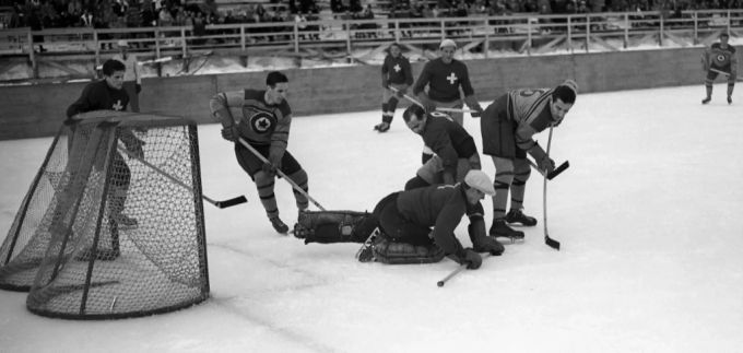 Der Schweizer Goalie hält einen Schuss der Kanadier im Spiel der Finalrunde an Olympia 1948. Eishockey WM