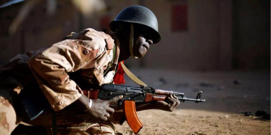 Ein Soldat aus Mali geht nimmt Schutz während eines Feuergefechts.