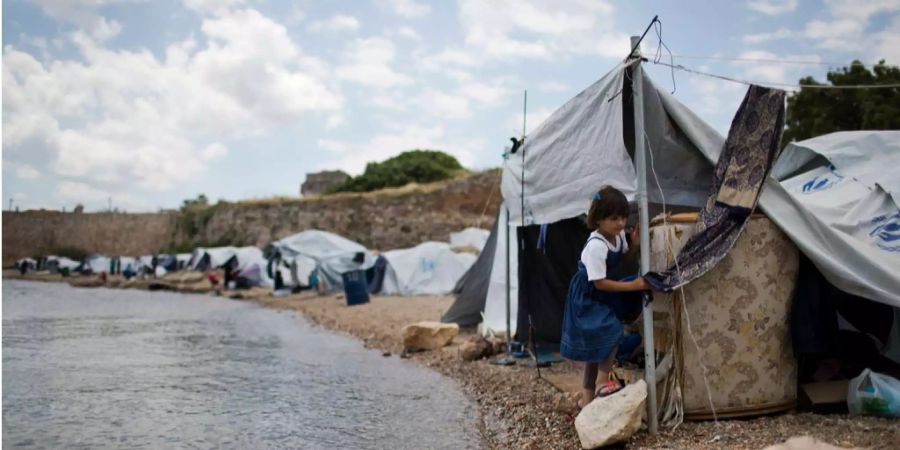 Ein syrisches Flüchtlingsmädchen bastelt am Zelt in einem griechischen Flüchtlingscamp. (Symbolbild)