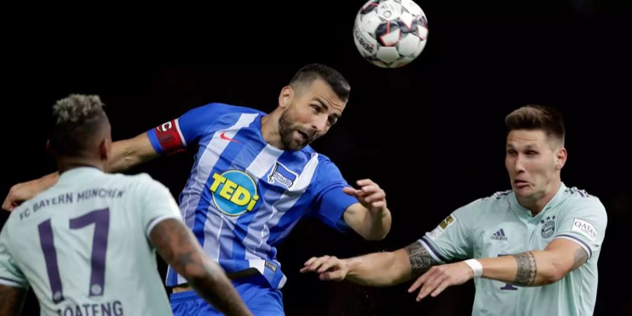Herthas Vedad Ibisevic erreicht den Ball vor Bayerns Boateng.