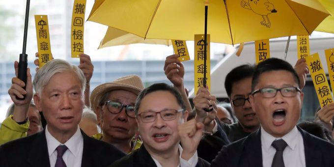 Die drei Aktivisten Chan Kin Man, Benny Tai und Chu Yiu Ming schreien auf dem Weg zum Gericht Parolen. (Archivbild) Hongkong