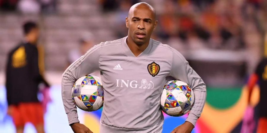 Thierry Henry läuft vor dem Spiel zwischen Belgien und der Schweiz mit zwei Bällen über den Platz.