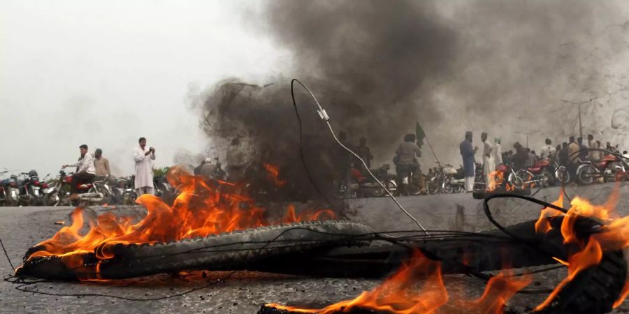 Demonstranten entzünden in Pakistans Hauptstadt Islamabad Feuer.