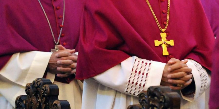 Bischöfe haben beim feierlichen Eröffnungsgottesdienst der Herbstvollversammlung im Dom in Fulda die Hände gefaltet.