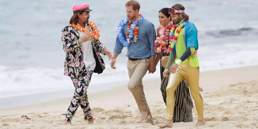 Prinz Harry und seine Frau Meghan spazieren barfuss am berühmten Bondi Beach in Sydney.