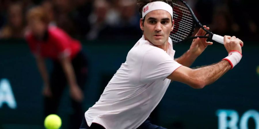 Roger Federer holt gegen Novak Djokovic zu einem Rückhand-Schlag aus.