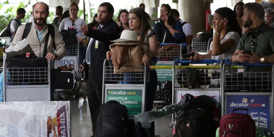 Kubanische Ärzte stehen mit ihrem Gepäck am Flughafen in Brasilia, bevor sie nach Kuba zurückreisen.