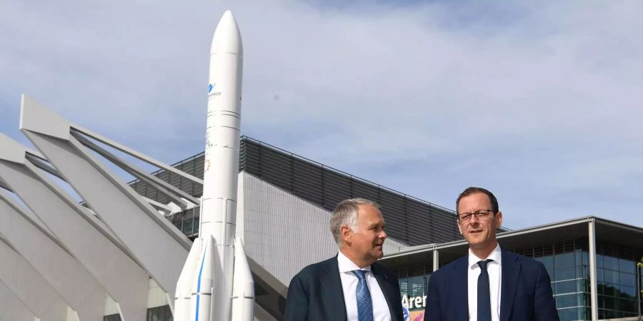 Martin Günthner (SPD, r), Bremens Senator für Wirtschaft, Arbeit und Häfen und Jens Lassmann, Standortleiter ArianeGroup Bremen, stehen vor einem Modell der Ariane 6