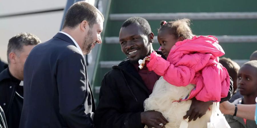 Matteo Salvini (l), Innenminister von Italien, spricht mit einem Migranten.