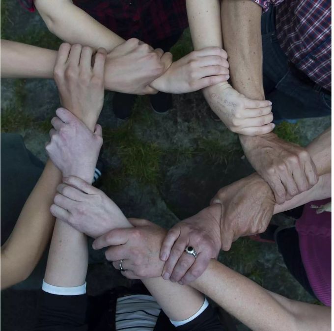Personen halten sich an den Handgelenken und formen einen Kreis - Keystone Personen halten sich an den Handgelenken und formen einen Kreis - Keystone
