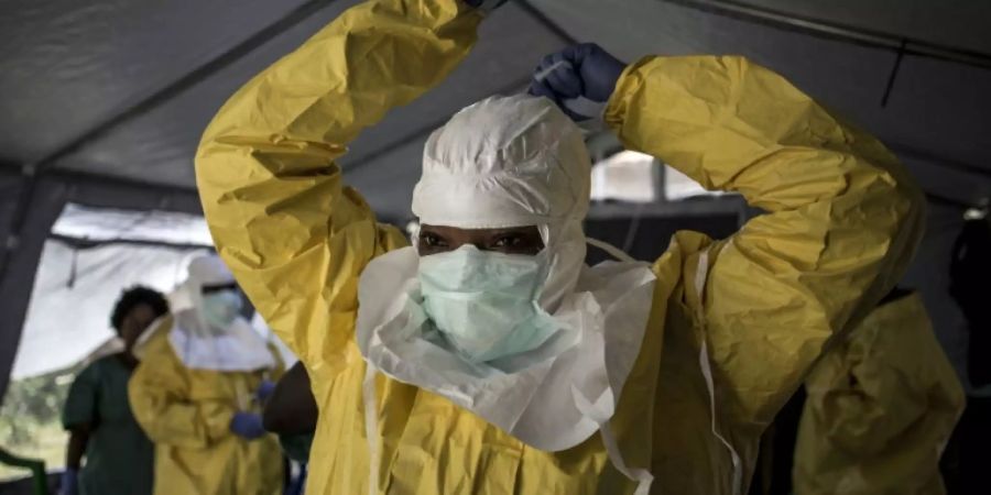 Helfer in Schutzkleidung kümmern sich um Opfer der Immunkrankheit Ebola.