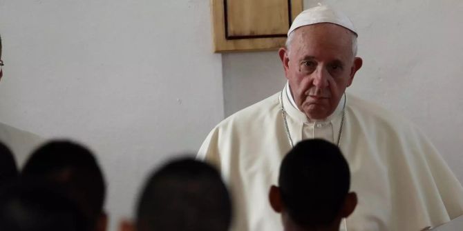 Papst Franziskus hört die Worte eines Insassen an.