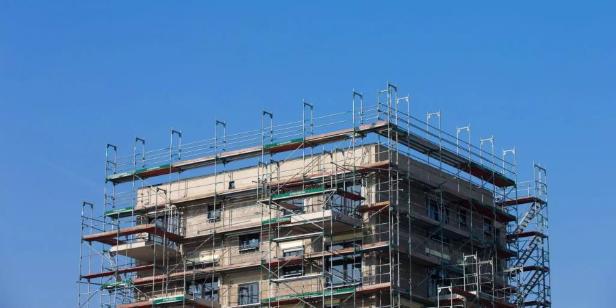 Gerüste stehen an einem Haus in dem Wohnungen gebaut werden.