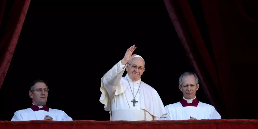 Papst Franziskus (M) steht auf dem Hauptbalkon des Vatikan.