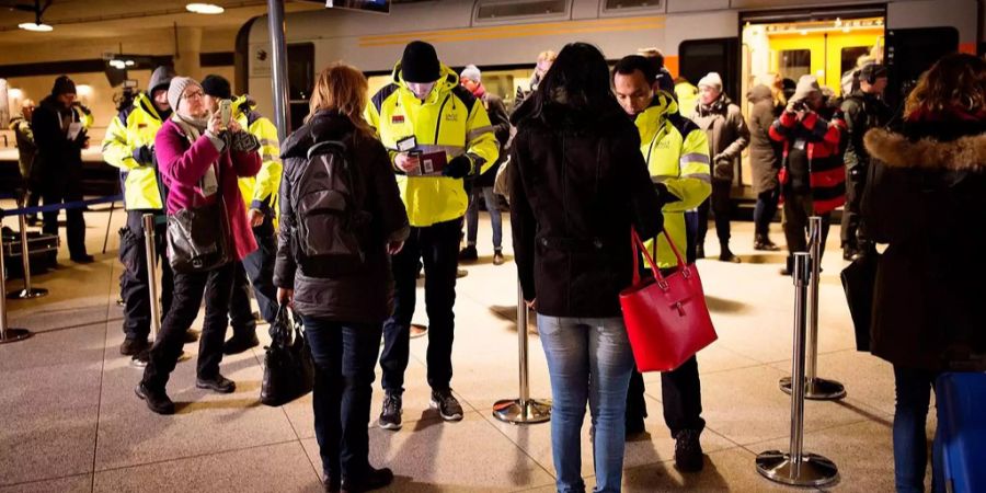 Dänische Grenzbeamte kontrollieren Reisepässe.