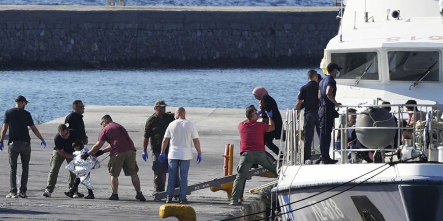 Ein Kind, das von Beamten der Küstenwache eskortiert wird, geht nach einer Rettungsaktion im Hafen von Mytilene mit anderen Migranten von Bord eines Schiffes. Fünf Migranten sind bei dem Versuch ums Leben gekommen, von der Türkei in Schlauchbooten zu den griechischen Inseln Lesbos und Samos überzusetzen. Foto: Panagiotis Balaskas/AP/dpa