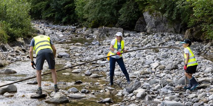 Rohrtransport beim Bach-Grümpi 2023. Personen fischen Alteisen aus Bach