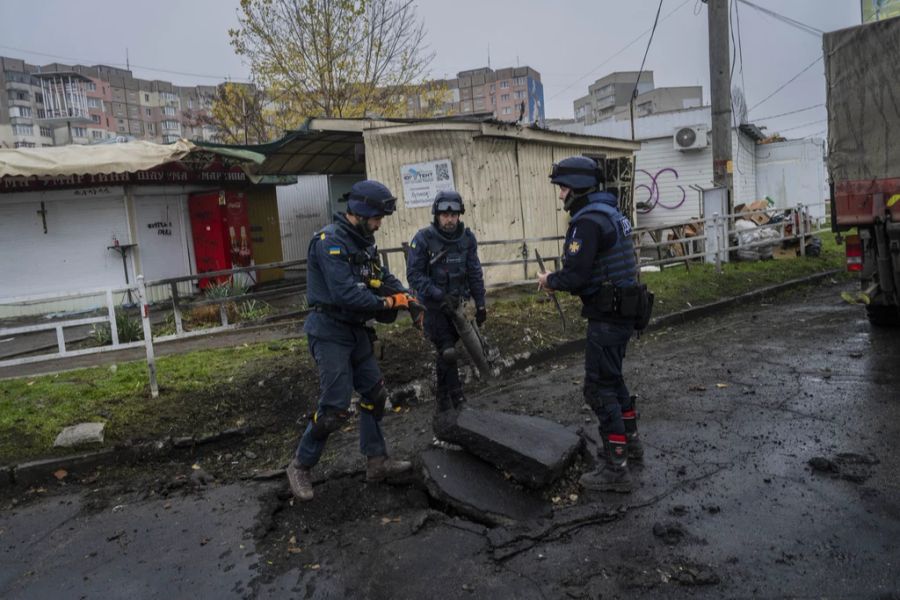 Ukrainische Pioniere sammeln die Überreste einer Rakete nach einem russischen Angriff in Cherson, Südukraine, am Donnerstag, 24. November 2022, ein.