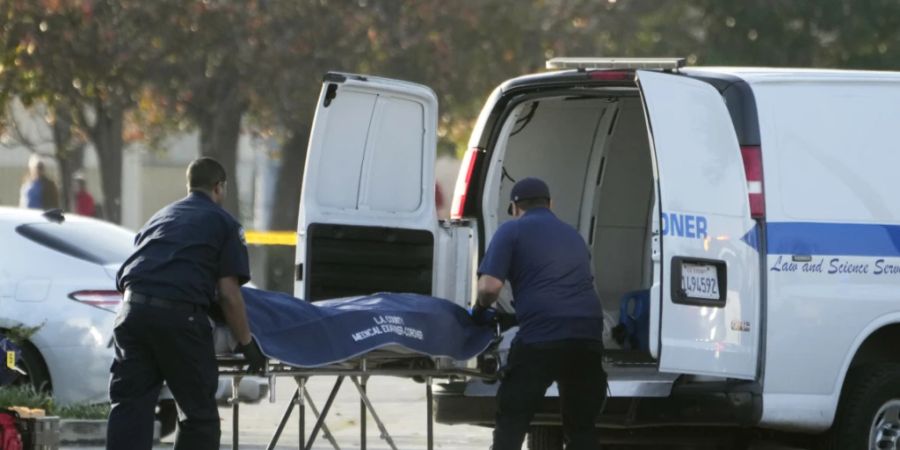 Die Leiche des mutmasslichen Todesschützen wird vom Gerichtsmediziner des Bezirks Los Angeles aus einem Lieferwagen in Torrance, Kalifornien, geholt. Foto: Damian Dovarganes/AP/dpa