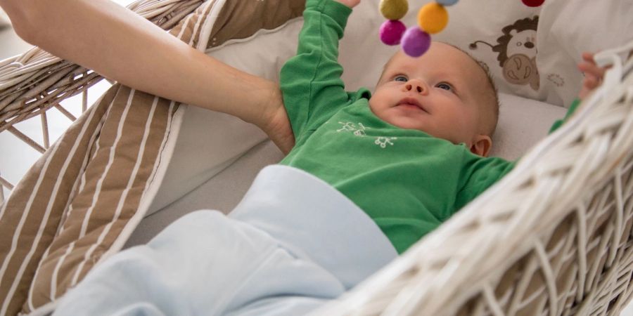 Eltern legen Säuglinge am besten in ein eigenes Bett auf eine feste Unterlage - und zwar ohne Decke, Kissen oder Kuscheltiere.