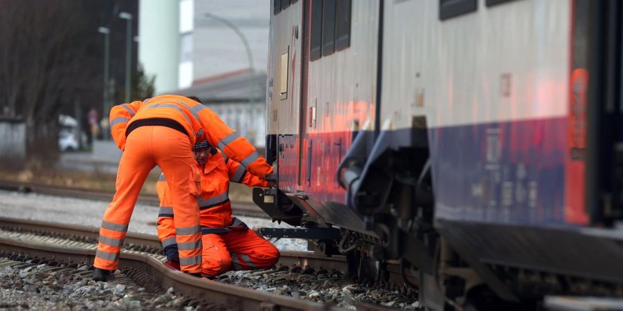 Bahnmitarbeiter begutachten den entgleisten Zug der Bayerischen Regiobahn.