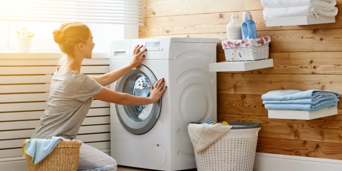 Frau schaltet Waschmaschine an