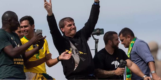 Jair Bolsonaro (M), Präsident von Brasilien, gestikuliert nach einer Motorradtour mit seinen Unterstützern. Bolsonaro hat die coronabedingten Gesundheitsvorschriften missachtet und sich ohne Maske von zahlreichen Menschen feiern lassen. Foto: Bruna Prado/AP Brasilianischer Präsident lässt sich von Anhängern feiern