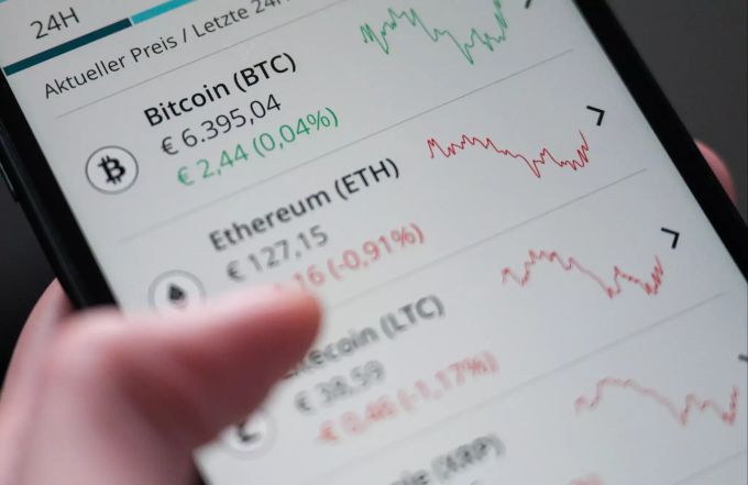 ILLUSTRATION - 16.12.2019, Baden-Württemberg, Stuttgart: ARCHIV - Eine Frau bedient die App «Bison» der Börse Stuttgart, mit der Kryptowährungen wie Bitcoin, Ethereum, Litecoin und Ripple über ein Smartphone gekauft und verkauft werden können. Erstmals Zahlung mit Kryptowährung bei Auktion von Banksy-Bild