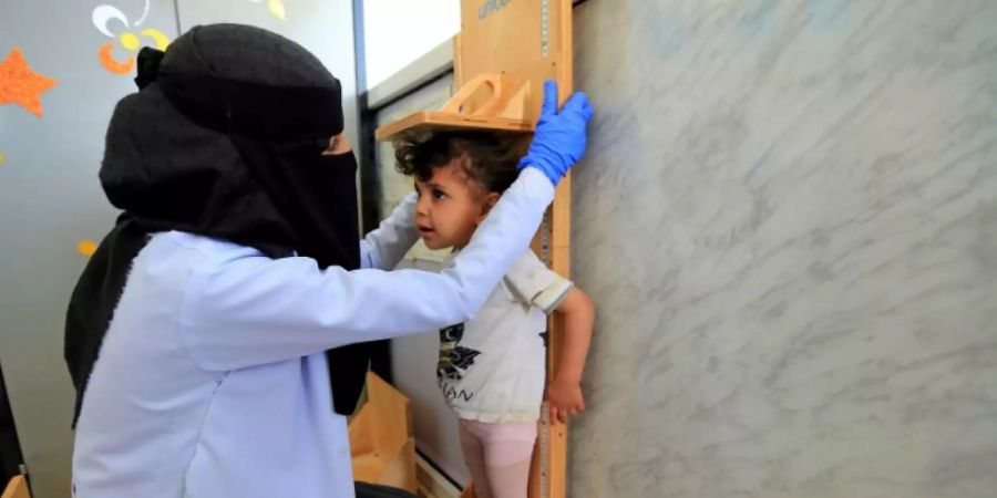 Klinik-Mitarbeiterin im Jemen untersucht ein Kleinkind