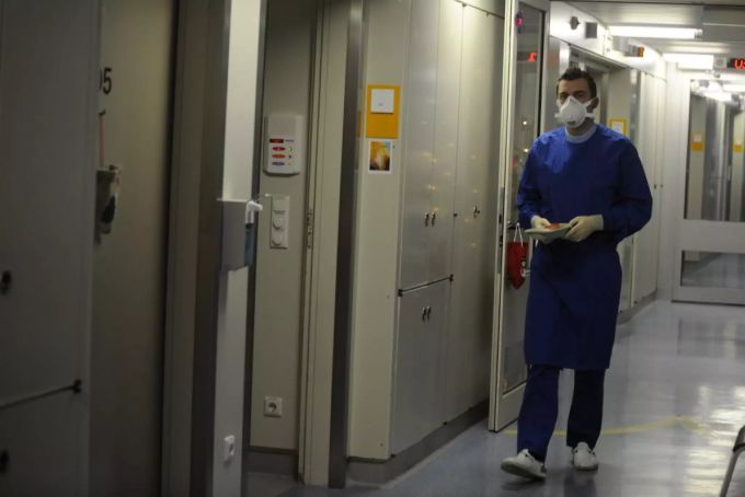 Ein Pfleger mit Mundschutz ist auf dem Weg in eine Infektionsstation. (Symbolbild) Pfleger