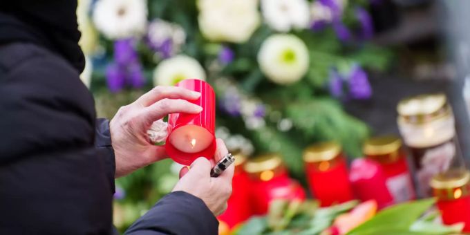 Eine Frau zündet zum Gedenken der Henau-Opfer eine Kerze an. Gedenkfeier in Hanau mit Bundespräsident