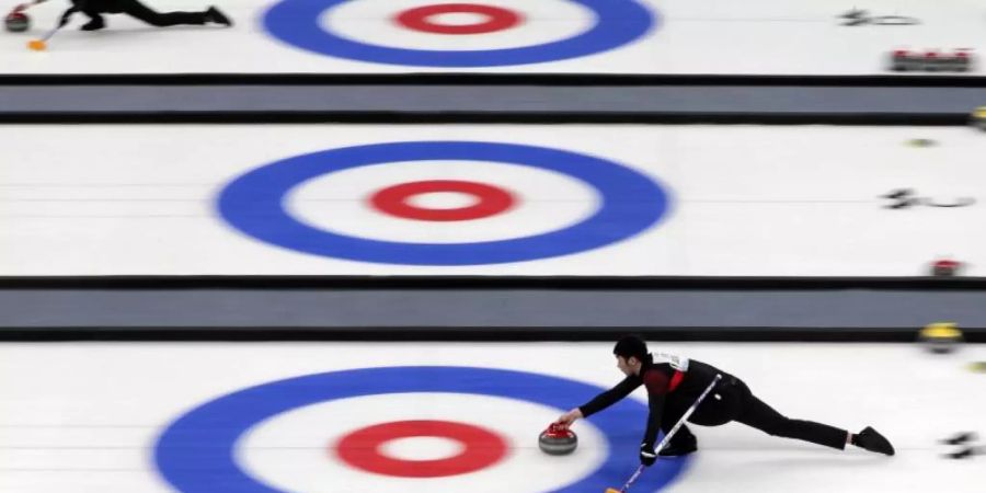 Curlingsportler treten bei einer Testveranstaltung für die Olympischen Winterspiele 2022 in Peking gegeneinander an. Foto: Andy Wong/AP/dpa