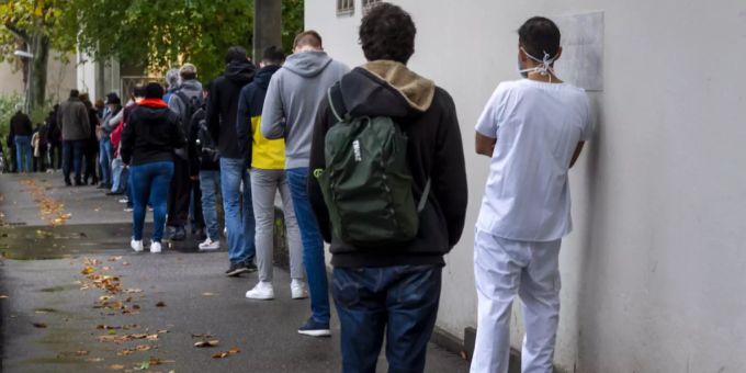 Menschen, inklusive ein Spitalangestellter, stehen Schlange vor dem Covid-19-Testzentrum des Universitätsspitals Basel, am 23. Oktober 2020. Coronavirus Testzentrum Spital