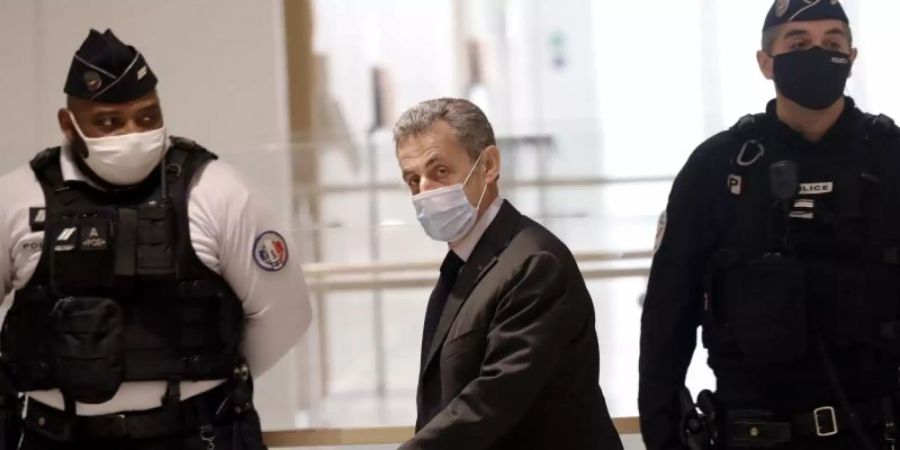 Nicolas Sarkozy (M), ehemaliger Präsident von Frankreich, trifft im Novembr 2020 zu einer Anhörung in einem Gerichtsgebäude in Paris ein. Foto: Christophe Ena/AP/dpa