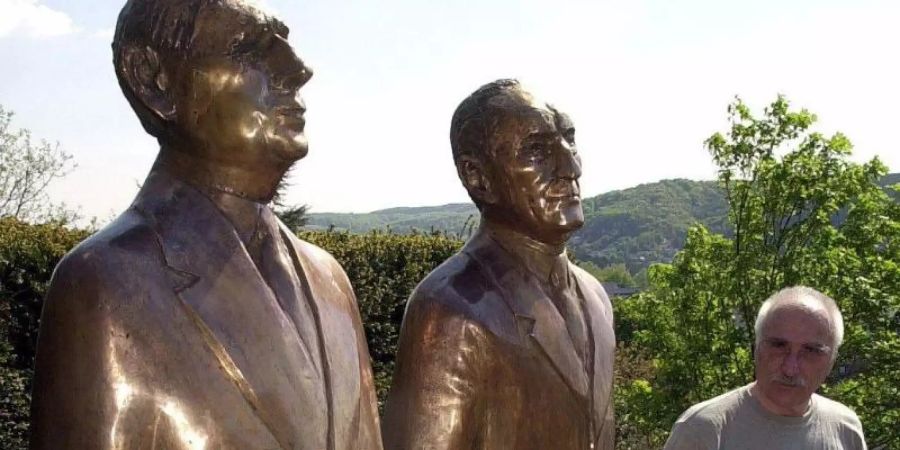 Imre Varga (r), ungarischer Bildhauer, an seiner Bronze am Adenauer-Haus in Rhöndorf bei Bonn. Foto: Roland Scheidemann/dpa
