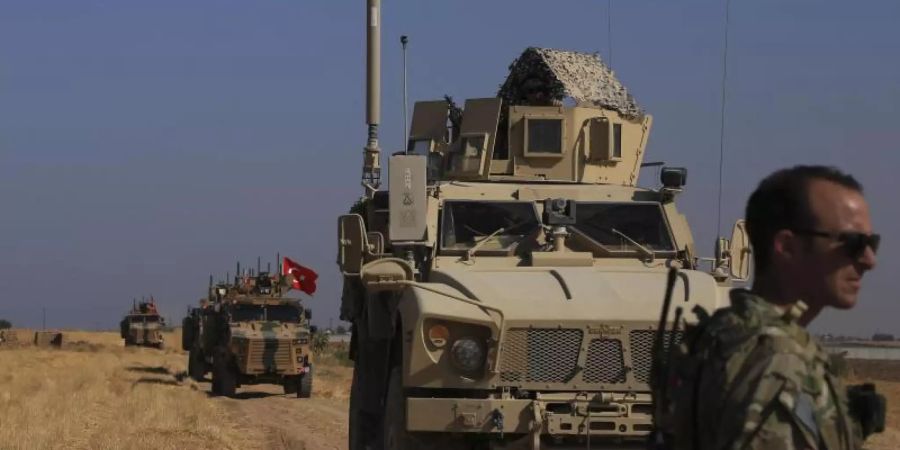 Türkische und amerikanische Panzerfahrzeuge patrouillieren bei Tal Abyad an der syrisch-türkischen Grenze. Foto: Baderkhan Ahmad/AP/dpa