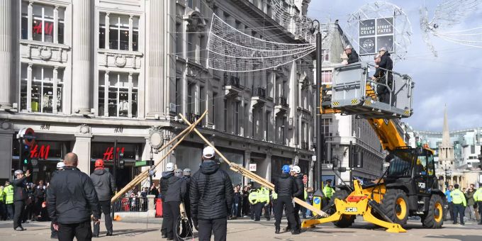 Polizisten entfernen eine Bambusstruktur auf einer Kreuzung. Aktivisten blockierten mit Hilfe von meterhohen Holzstangen den Oxford Circus. Extinction Rebellion - London