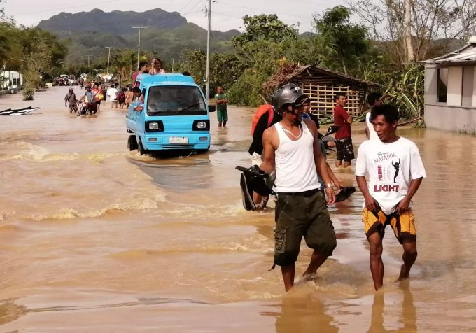 Menschen laufen auf den Philippinen am Weihnachtstag auf überfluteten Strassen. Philippinen Taifun Phanfone