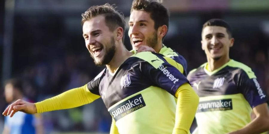 Osnabrücks Torschütze David Blacha (l-r) feiert mit Bashkim Ajdini und Anas Ouahim den Treffer zum 3:2 gegen Holstein Kiel. Foto: Frank Molter/dpa