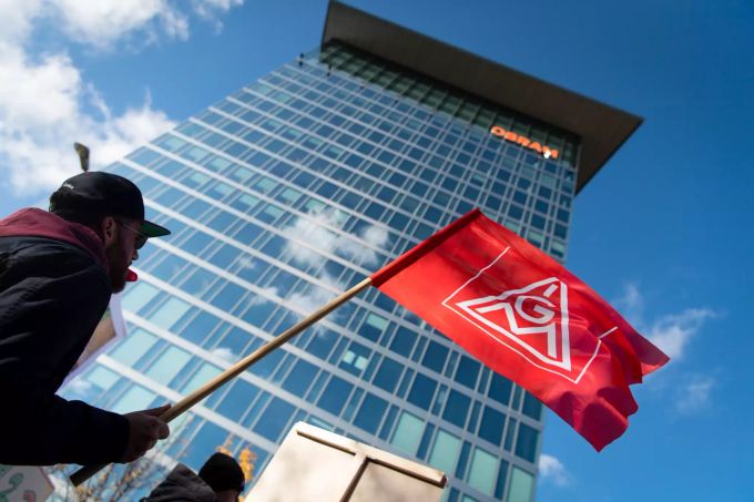 Ein Osram-Beschäftigter hält bei einer Protestaktion Mitte November vor der Osram-Konzernzentrale eine IG-Metall Fahne. Die Mitarbeiter aus mehreren bayerischen Standorten wollen sich mit ihrer Kundgebung gegen einen von Osram geplanten Abbau von 800 Arbeitsplätzen in Deutschland wehren. Osram
