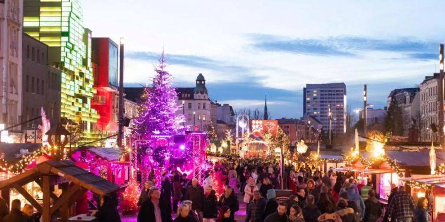 Auf dem Weihnachtsmarkt «Santa Pauli» auf dem Spielbudenplatz können Besucher auch einen Holzdildo-Verkaufstand durchstöbern. Foto: Christian Charisius/dpa
